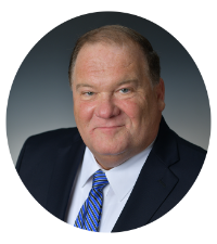 Headshot of Kentucky Farmers Bank SVP/ Loan Officer. He is smiling, wearing a suit with a blue tie against a grey background.